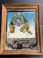 Front view of the framed vintage glass mirror showing Green Bay Packers players and NFL branding