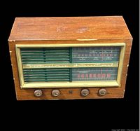 Front view of vintage Westinghouse wood cabinet tube radio with four knobs and frequency dial with AM radio bands.