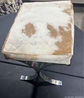 Top view of bench seat showing cowhide upholstery with brown and white patches.