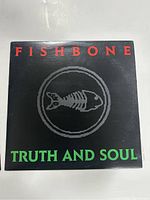 Front cover of Fishbone Truth and Soul vinyl record sleeve, black background with red and green text and a skeleton fish logo