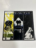 Front cover of Tones On Tail self-titled vinyl showing artwork with three vertical panels and the band name.