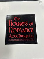 Back cover of The Flowers of Romance vinyl, showing red gothic text on black background with title and band name, track listing provided.