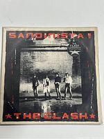 Front cover of The Clash's Sandinista! 3xLP album with band photo and red text