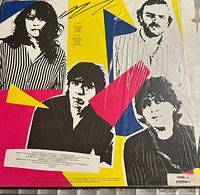 Back cover of the vinyl record sleeve with band members and colorful geometric background, showing band details and credits.