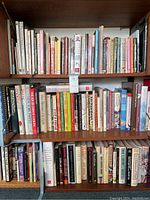 Bookshelves filled with various hardcover cookbooks on international and American cuisine including hors d'oeuvres, desserts, entertaining, and snacks.