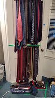 Multiple neckties hung on a two-tier rack showing top and bottom rows of ties.