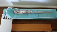 Full view of letter opener resting on Tiffany blue suede pouch atop matching box