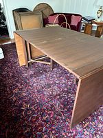 Table expanded partway showing sacrificial leaves and wear on surface.