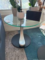 Full view of round glass top end table showing overall design