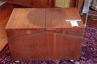 Front view of closed cabinet showing wood veneer panels and caster wheels