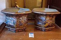 Front view of two hexagonal planter pots on bases