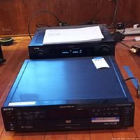 Sony 5-disc DVD/CD changer player and Denon AVR-1908 AV receiver stacked on a table with power cords visible, showing front view.