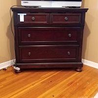 3-drawer dark wooden dresser with TV on top, solid wood construction, two small drawers on top separated by middle fold-down drawer and one large bottom drawer.