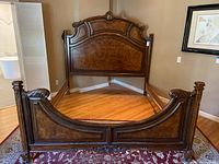 Front view of the wooden king size bed frame showing the headboard and footboard with carved details.