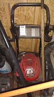 Top view partially obscured showing red Briggs & Stratton engine with 6.5 HP label under black frame handle.
