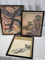 Three framed Japanese art pieces: color horse print, color fishing beneath pine print, monochromatic brush painting of man on mountain slope.