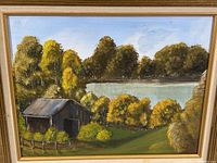 Close-up view of the unsigned oil painting showing the barn, lake, and wooded landscape with rich greens and yellows, framed in a gold painted wood frame.