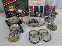 Full collection of silver plated tableware including fruit/bread basket, serving dishes, candle sticks, and coasters in box