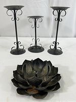 All four vintage metal candle holders displayed on white background: two tall matching holders, one smaller holder, and one lotus-inspired holder