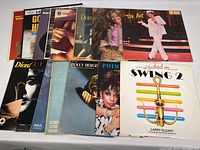Photo showing 11 vinyl album covers in two rows, featuring soul, swing, Broadway, and vocal artists with visible wear on sleeves.