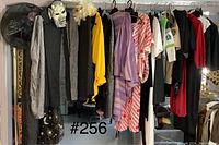 Photo of various Halloween costumes hanging on a rack with masks and accessories attached