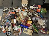 Full view of mixed lot items spread out showing a variety of household, collectibles and decor items.