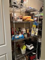 Photo showing the 6 tier metal shelving unit loaded with various household items to illustrate scale and usage. Items are not included in sale.