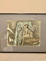 Photo of framed cowboy-themed print showing a denim jacket draped over a wooden chair.