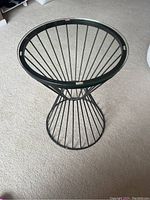 Top view showing round glass top with some missing glass stoppers and viewing the wire frame base below.