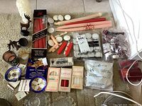 Lot overview showing assorted candles, boxed candles, tea lights, taper candles, and multiple candle holders including reindeer shapes and decorative styles.