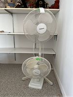 Holmes floor fan (approx. 40 in.) standing behind Duracraft table fan (approx. 19 in.) showing overall size and design.