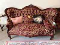 Front view of the settee showing button-tufted back and four cushions