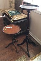 Two wood tables are side-by-side on a wood floor near a window, showing the taller plant stand and smaller side table profiles.