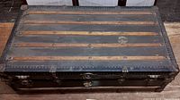 Top view of the antique trunk showing wood slats and metal rivets