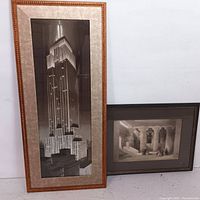 Front view of Empire State Building black and white print framed, alongside smaller framed classical interior print