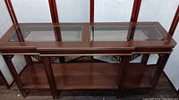 Top-down photo of the rectangular glass top of the wooden console table showing the two inset clear glass panels and wooden frame.