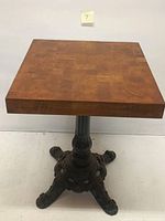 Square solid wood table top of the high table showing wood grain pattern and edges