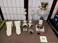Full lot on table showing all items: two candlesticks, two sconces, figurine, mineral stone, and glass lamp with power cord.