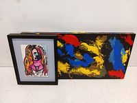 Photo showing two pieces of modern art together: a colorful abstract painting and a framed portrait sketch