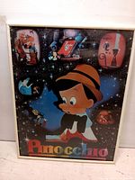 Framed Disney Pinocchio poster with starry night background and multiple film scenes.