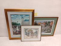 Three framed signed numbered lithograph prints displayed together, showing varying frame styles and sizes