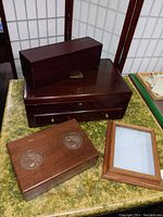 Overview of four wooden boxes and frame on green fabric surface