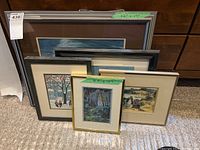 Five framed artworks of various sizes displayed on carpet
