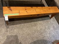 Full length view of the wooden bench showing the top surface and heart-shaped cutouts on the front panel.