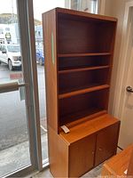 Full view of cabinet showing open shelves above cupboard base.