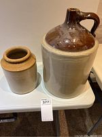 Both ceramic jug and small pot placed on a white table showing size and shape contrast.