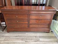 Front view showing two shallow top drawers and six lower drawers on cherry finish dresser