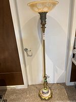 Full view of floor lamp showing entire height, base, stem and glass shade.