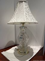 Full view of glass base lamp with cream fabric shade featuring leaf pattern, showing overall size and condition.