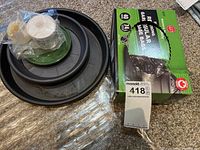 Photo showing black plastic step stool, box of black garbage bags, green memory foam mat, and polishes.